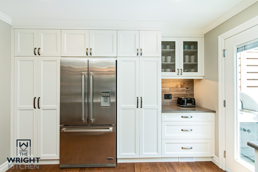 Inspiration for a large transitional medium tone wood floor and brown floor kitchen remodel in Toronto with an undermount sink, shaker cabinets, white cabinets, wood countertops, blue backsplash, mosaic tile backsplash, stainless steel appliances, an island and white countertops