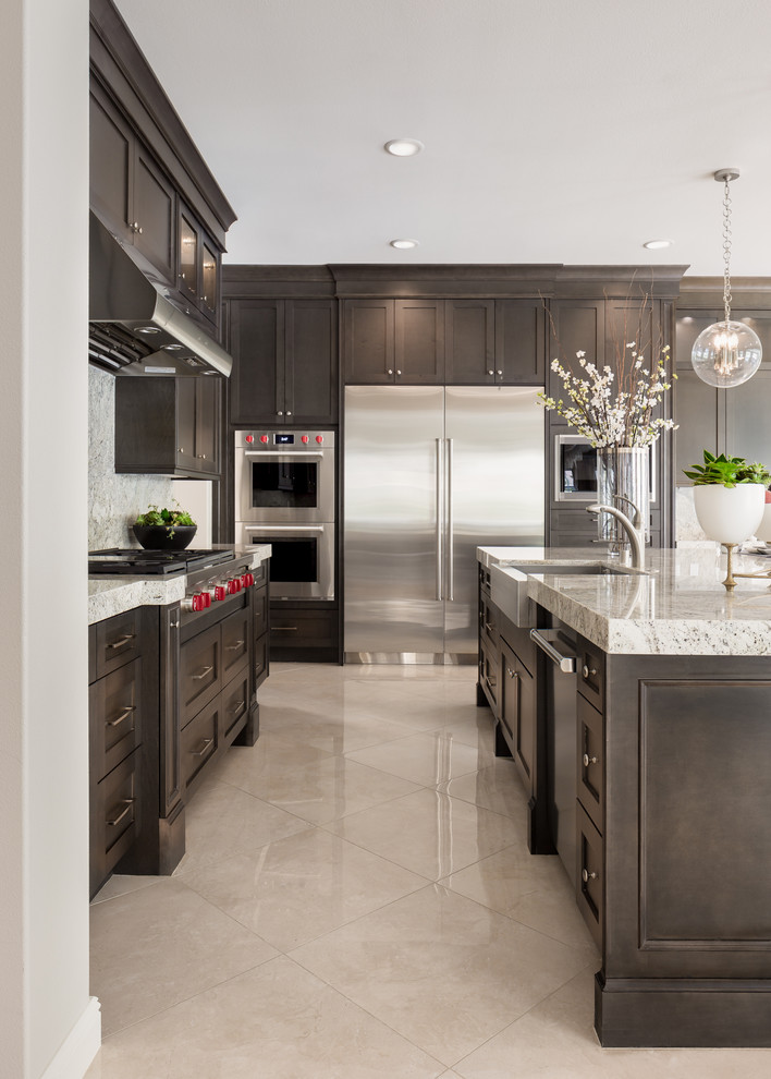 Eat-in kitchen - transitional beige floor eat-in kitchen idea in Orange County with dark wood cabinets, stainless steel appliances and an island