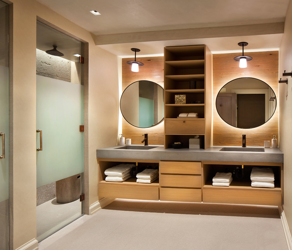 Alcove shower - rustic alcove shower idea in New York with flat-panel cabinets, medium tone wood cabinets, beige walls, an integrated sink, concrete countertops and a hinged shower door