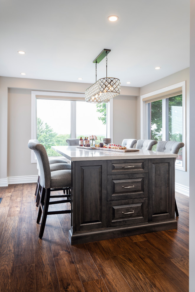 Eat-in kitchen - large transitional u-shaped dark wood floor and brown floor eat-in kitchen idea in Toronto with an undermount sink, recessed-panel cabinets, white cabinets, quartz countertops, white backsplash, ceramic backsplash, stainless steel appliances, an island and white countertops