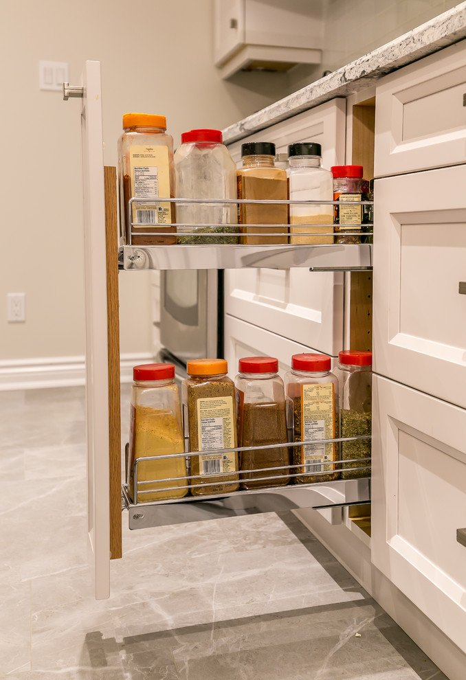 Inspiration for a large transitional gray floor enclosed kitchen remodel in Toronto with an undermount sink, recessed-panel cabinets, white cabinets, quartz countertops, white backsplash, ceramic backsplash, stainless steel appliances and an island