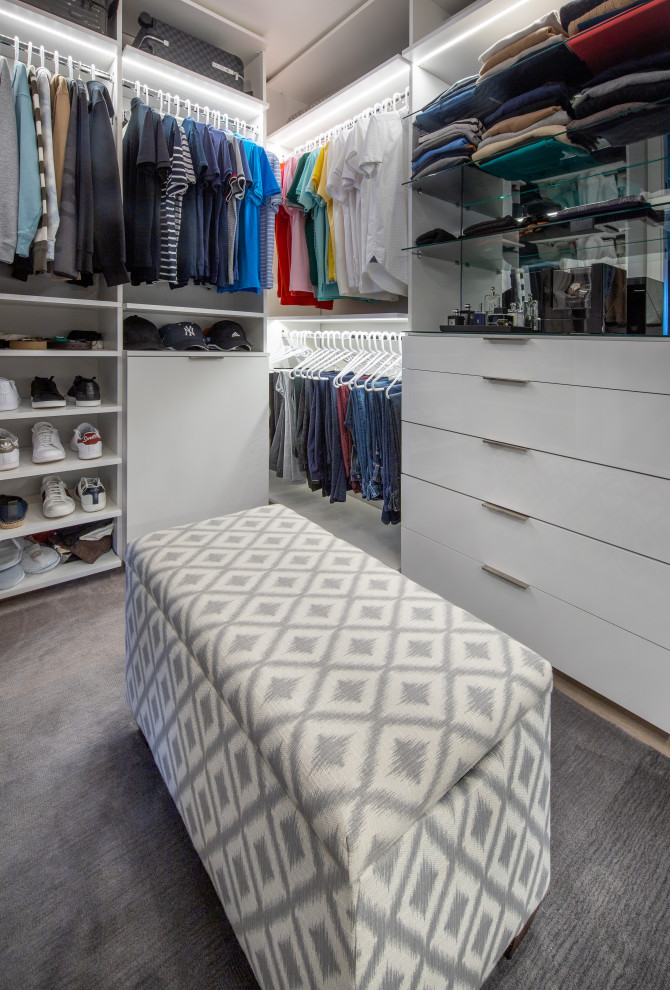 Photo of a mid-sized contemporary gender-neutral storage and wardrobe in Miami with flat-panel cabinets and white cabinets.