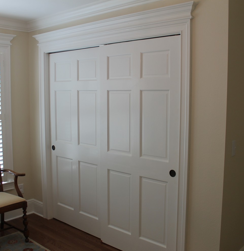 This is an example of a mid-sized traditional gender-neutral built-in wardrobe in Miami with medium hardwood floors.