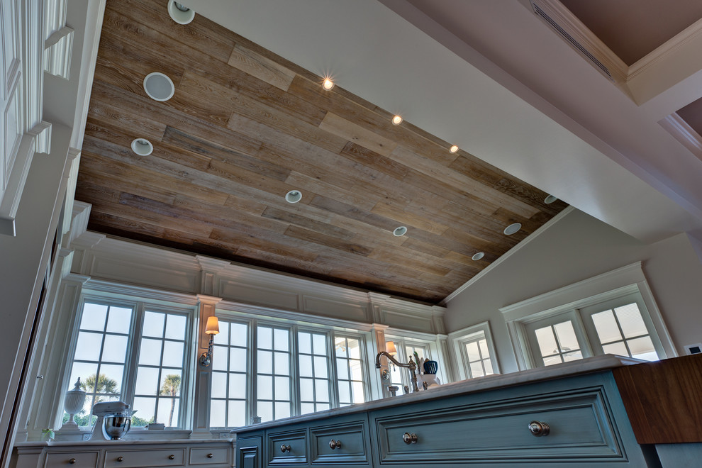 Large transitional l-shaped medium tone wood floor and brown floor eat-in kitchen photo in Miami with a farmhouse sink, raised-panel cabinets, blue cabinets, quartzite countertops, white backsplash, subway tile backsplash, stainless steel appliances and an island