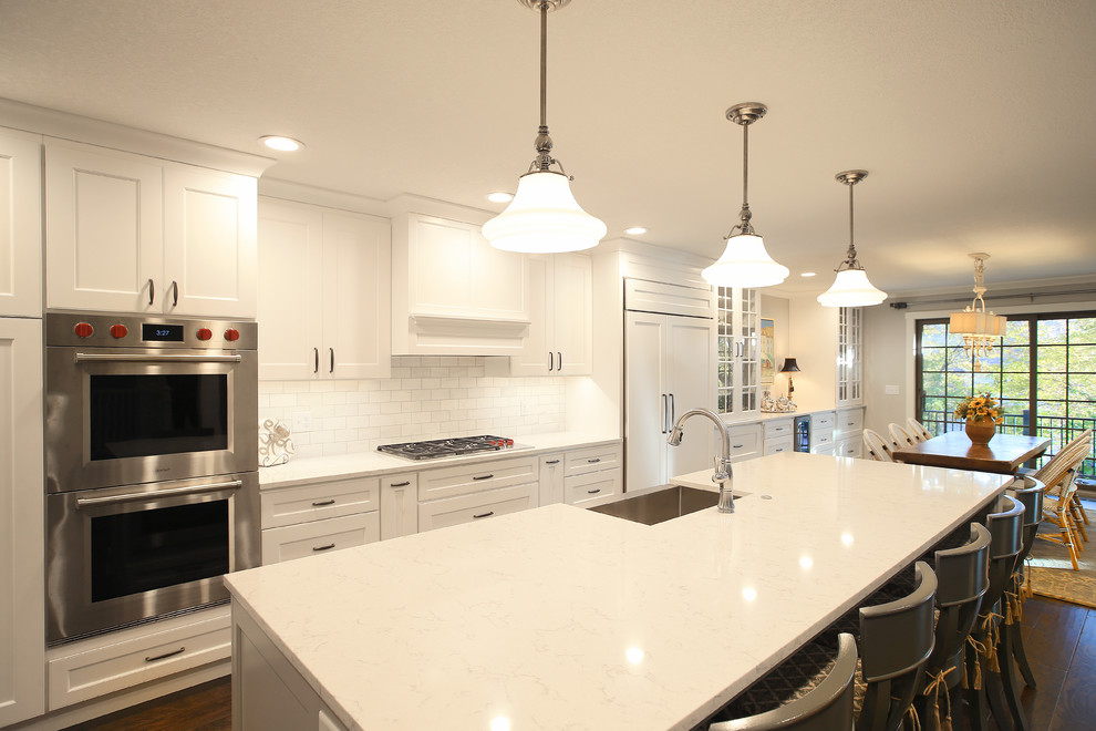 Example of a large transitional galley dark wood floor eat-in kitchen design in Chicago with a farmhouse sink, flat-panel cabinets, white backsplash, marble backsplash and stainless steel appliances