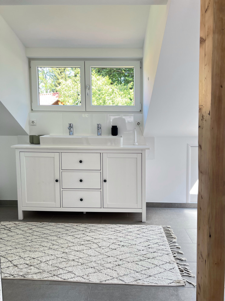 Badezimmer En Suite mit Kassettenfronten, hellen Holzschränken, Einbaubadewanne, offener Dusche, Wandtoilette, grauen Fliesen, Zementfliesen, grauer Wandfarbe, Zementfliesen für Boden, Aufsatzwaschbecken, grauem Boden, beiger Waschtischplatte, Einzelwaschbecken, schwebendem Waschtisch und eingelassener Decke in Munich
