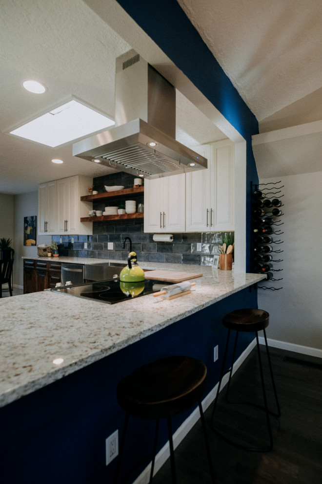 Design ideas for a mid-sized contemporary u-shaped eat-in kitchen in Albuquerque with a farmhouse sink, white cabinets, blue splashback, glass tile splashback, stainless steel appliances, dark hardwood floors, no island, brown floor and multi-coloured benchtop.