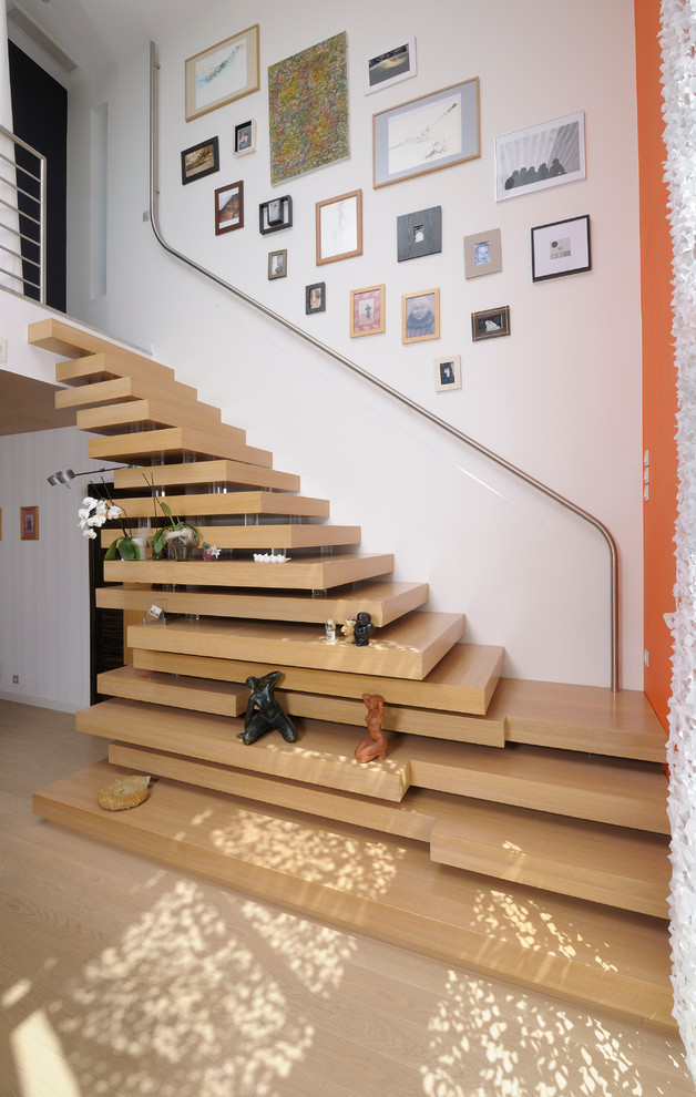 This is an example of a mid-sized contemporary wood floating staircase in Angers with open risers.
