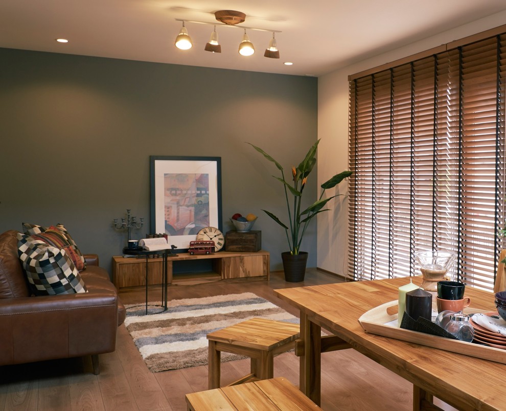 This is an example of an asian open concept living room in Other with green walls and medium hardwood floors.