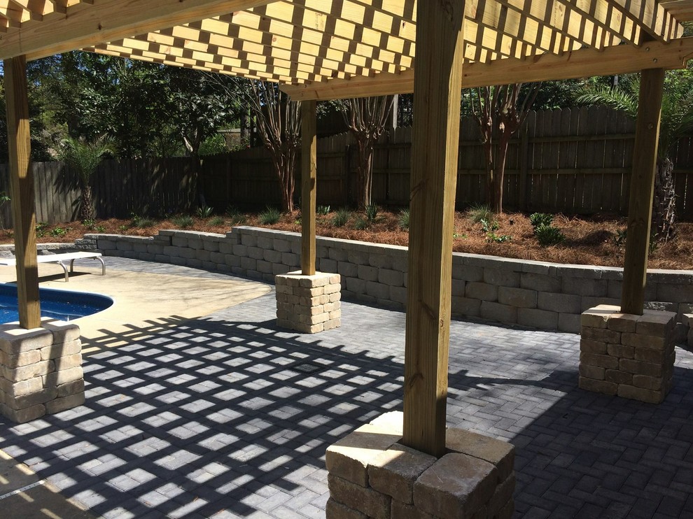 Photo of a large traditional backyard patio in Other with brick pavers and a pergola.