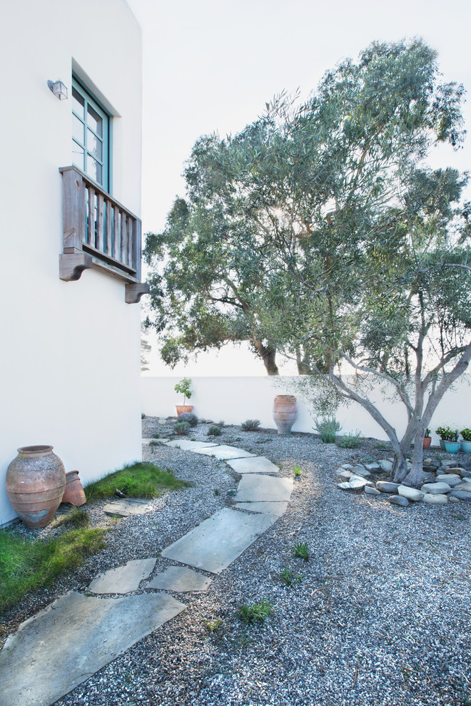 Inspiration for a large mediterranean partial sun garden in Santa Barbara with a garden path and natural stone pavers.