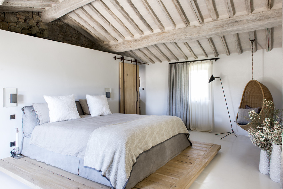 Country master bedroom in Paris with white walls and porcelain floors.