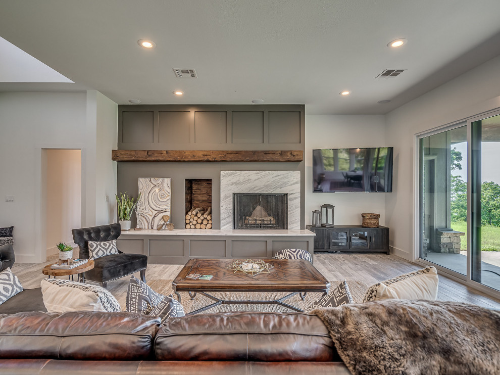 This is an example of a large arts and crafts open concept living room with white walls, ceramic floors, a standard fireplace, a stone fireplace surround, a corner tv and grey floor.