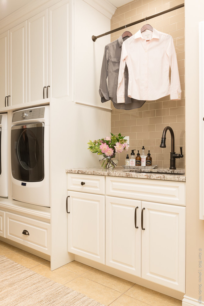 Design ideas for a mid-sized traditional galley laundry room in St Louis with an undermount sink, raised-panel cabinets, white cabinets, granite benchtops, beige walls, porcelain floors, a side-by-side washer and dryer and beige floor.
