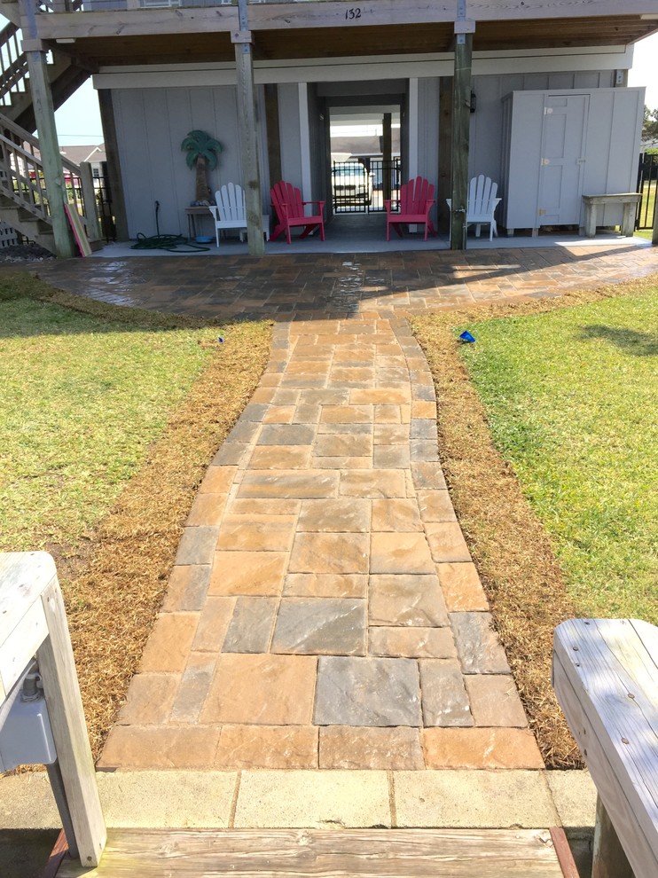 Photo of a mid-sized beach style backyard patio in Other with concrete pavers and no cover.