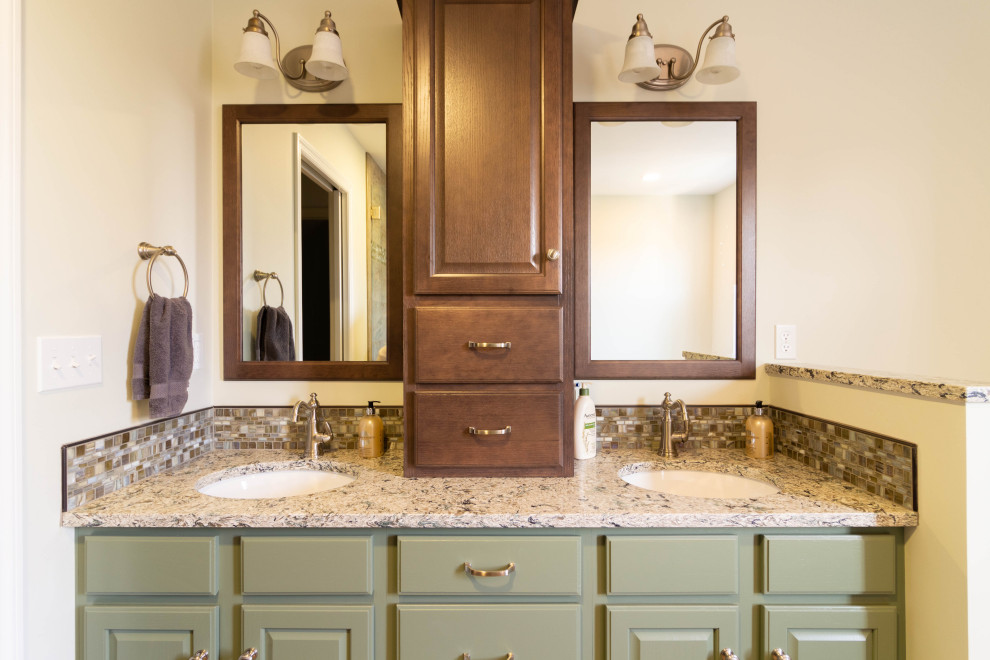 Design ideas for a mid-sized traditional master bathroom in Other with raised-panel cabinets, green cabinets, a drop-in tub, a corner shower, a two-piece toilet, beige tile, porcelain tile, beige walls, porcelain floors, an undermount sink, quartzite benchtops, brown floor, a hinged shower door and brown benchtops.