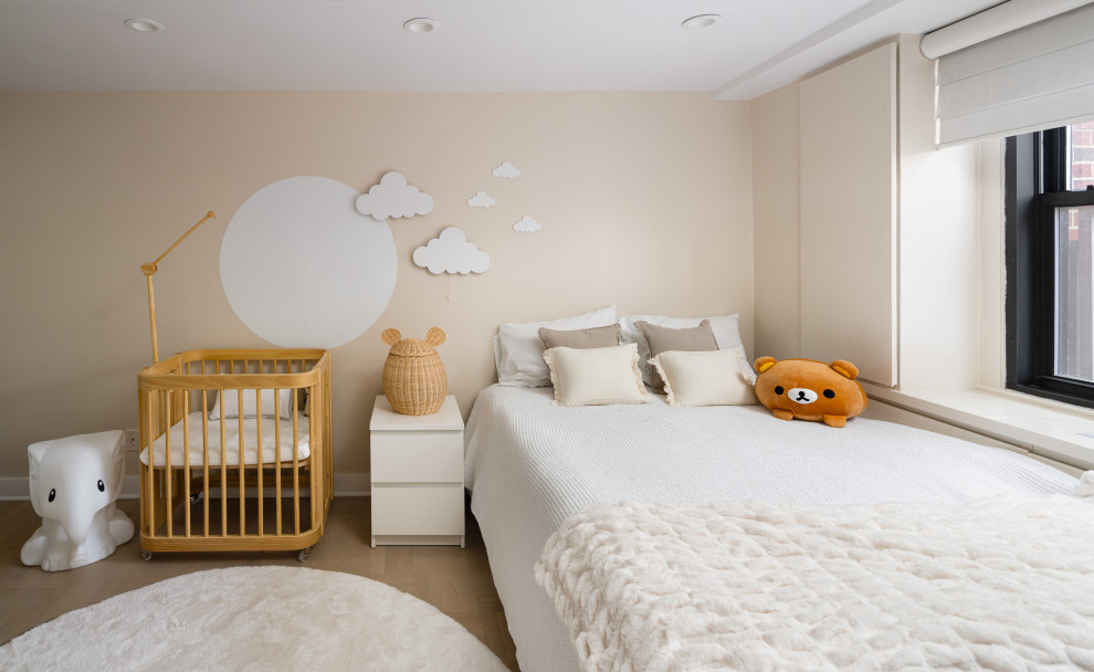 Exemple d'une chambre de bébé garçon moderne de taille moyenne avec un mur beige, parquet clair, un sol blanc et du papier peint.