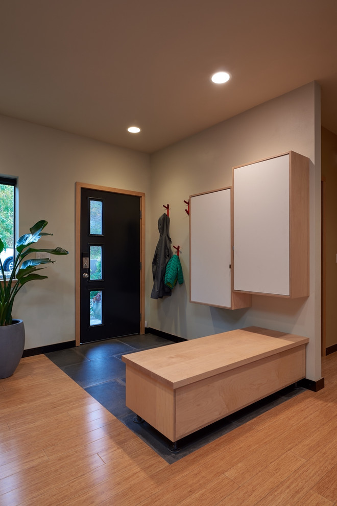 This is an example of a mid-sized modern foyer in Seattle with bamboo floors, beige walls and a single front door.