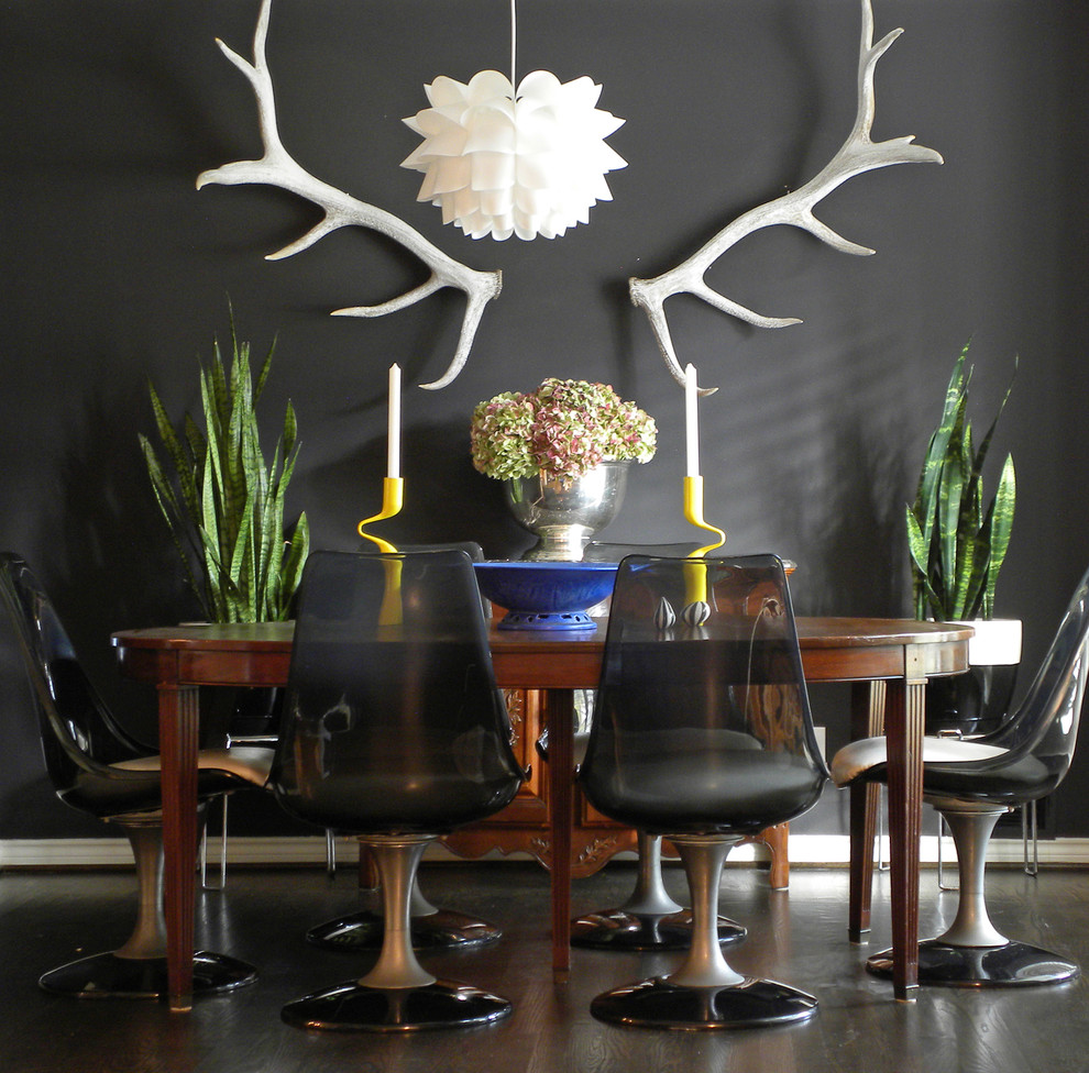 Inspiration for an eclectic dining room in Dallas with black walls and dark hardwood floors.