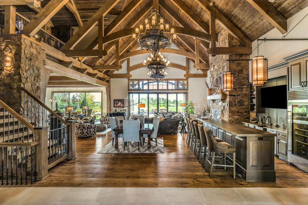 Country open plan dining in Chicago with white walls, dark hardwood floors and brown floor.