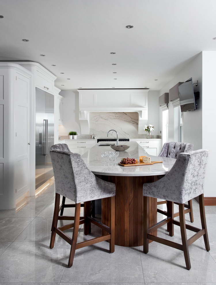 Photo of a mid-sized transitional l-shaped open plan kitchen in Other with an integrated sink, shaker cabinets, blue cabinets, marble benchtops, grey splashback, marble splashback, stainless steel appliances, porcelain floors, with island and grey floor.
