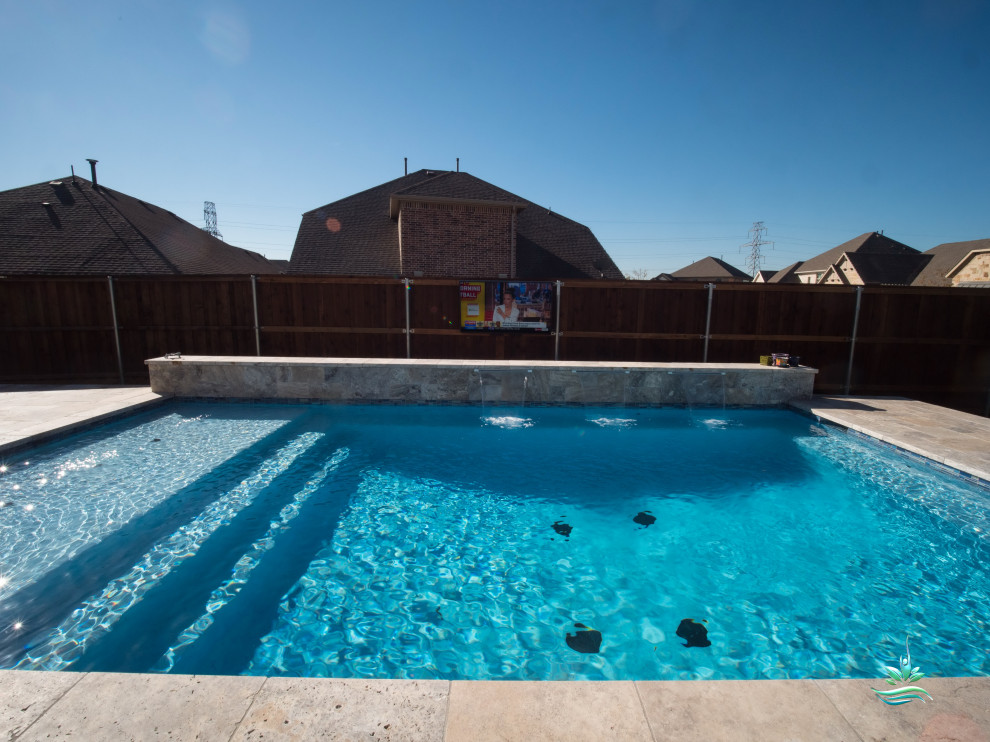 This is an example of a mid-sized modern side yard rectangular lap pool in Dallas with with a pool and natural stone pavers.
