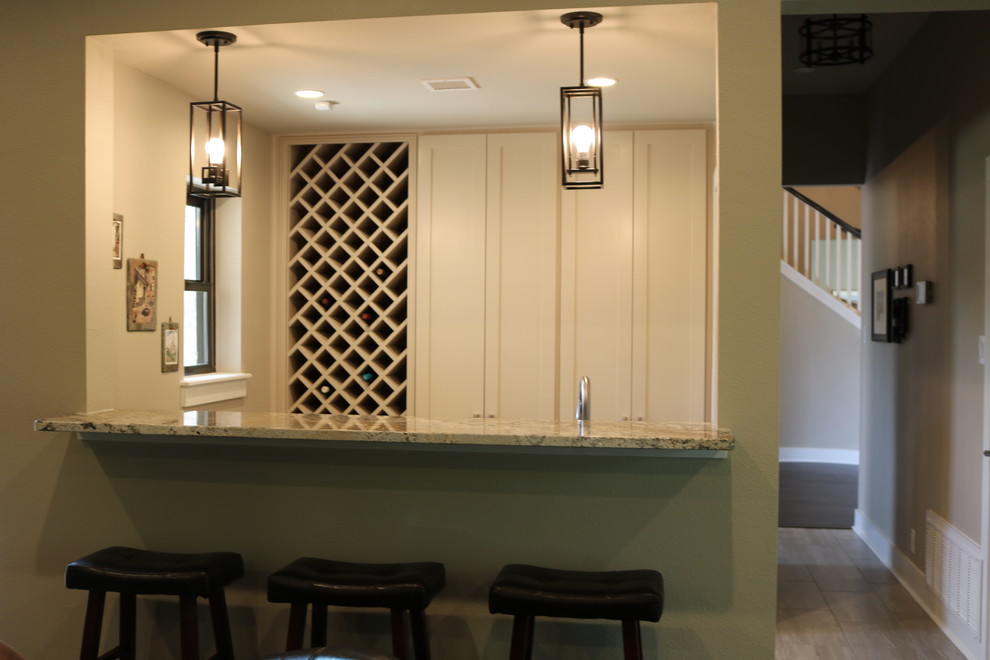 This is an example of a transitional wet bar in Austin with shaker cabinets, white cabinets, quartzite benchtops, porcelain floors, beige floor and multi-coloured benchtop.