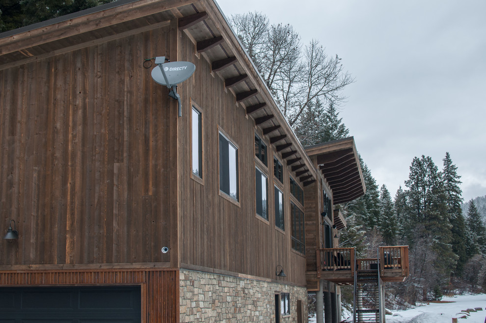 Mid-sized country two-storey brown exterior in Denver with wood siding and a flat roof.