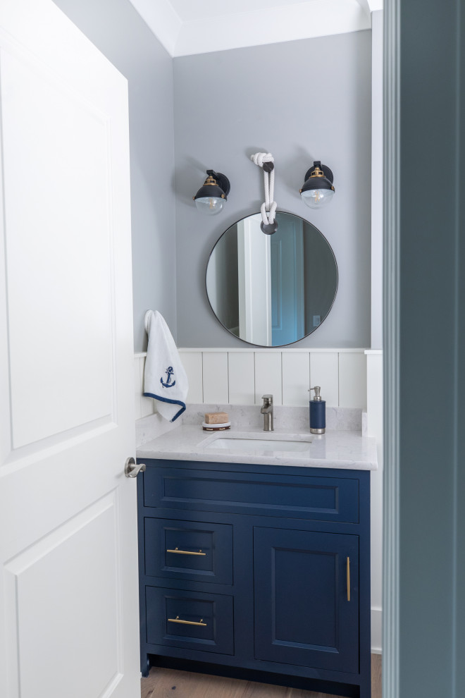 This is an example of a small beach style 3/4 bathroom in Milwaukee with flat-panel cabinets, blue cabinets, grey walls, medium hardwood floors, an undermount sink, engineered quartz benchtops, beige floor, beige benchtops, a single vanity and a built-in vanity.