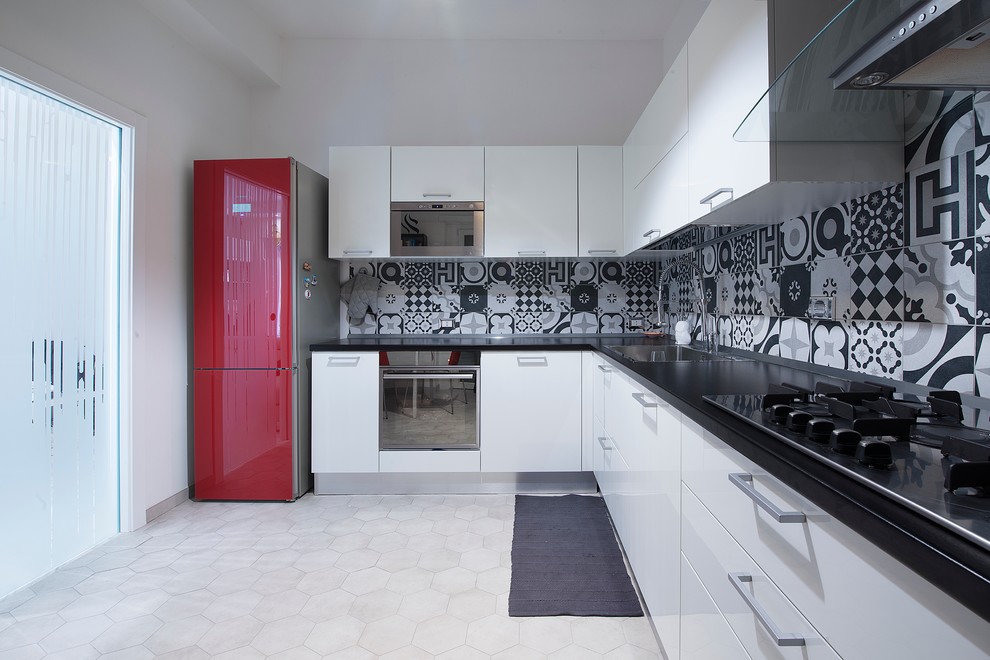 This is an example of a mid-sized contemporary l-shaped kitchen in Rome with flat-panel cabinets, white cabinets, solid surface benchtops, multi-coloured splashback, ceramic splashback, ceramic floors, a single-bowl sink and coloured appliances.