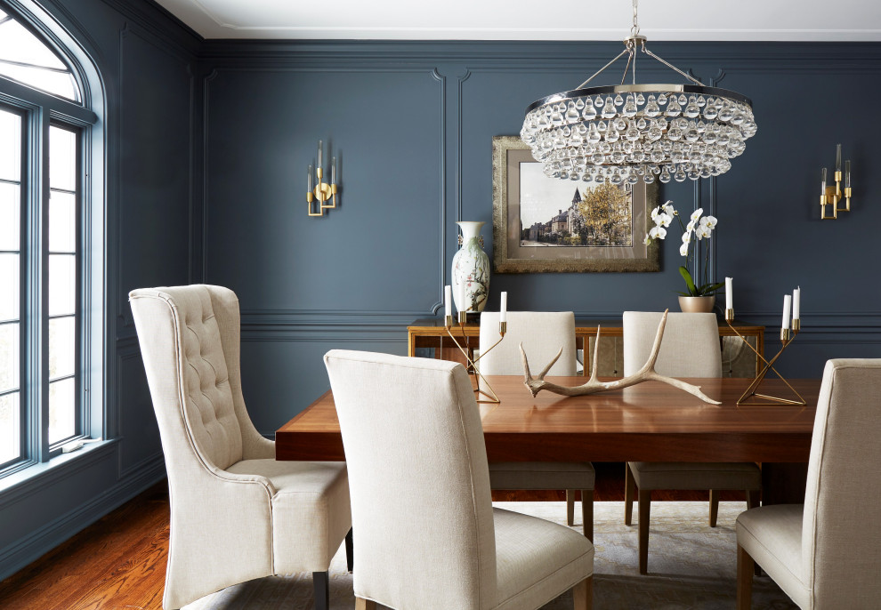 Inspiration for a large transitional separate dining room in Chicago with grey walls, medium hardwood floors, brown floor and panelled walls.