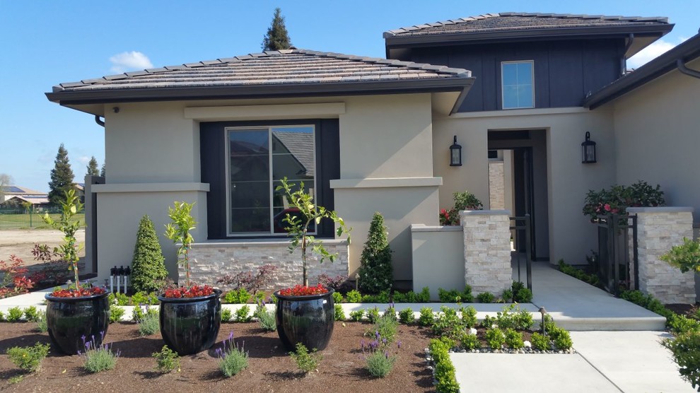 Inspiration for a large transitional beige one-story stucco gable roof remodel with a tile roof