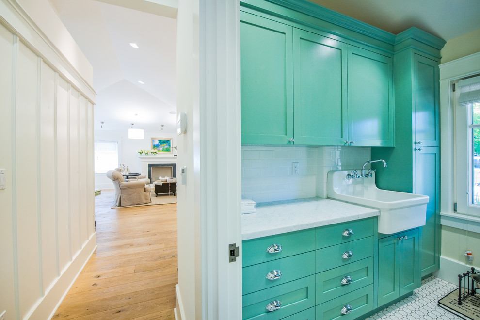 Inspiration for a mid-sized country galley utility room in San Francisco with a farmhouse sink, recessed-panel cabinets, green cabinets, beige walls, marble benchtops, ceramic floors, a side-by-side washer and dryer and white floor.