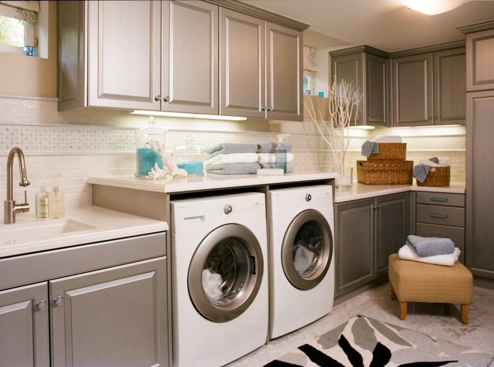 Design ideas for a traditional laundry room in Los Angeles with an undermount sink, raised-panel cabinets, grey cabinets, a side-by-side washer and dryer and grey floor.