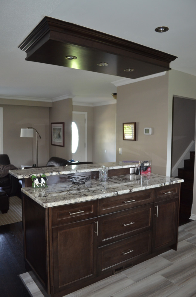 Eat-in kitchen - transitional eat-in kitchen idea in Toronto with shaker cabinets, dark wood cabinets, granite countertops and an island