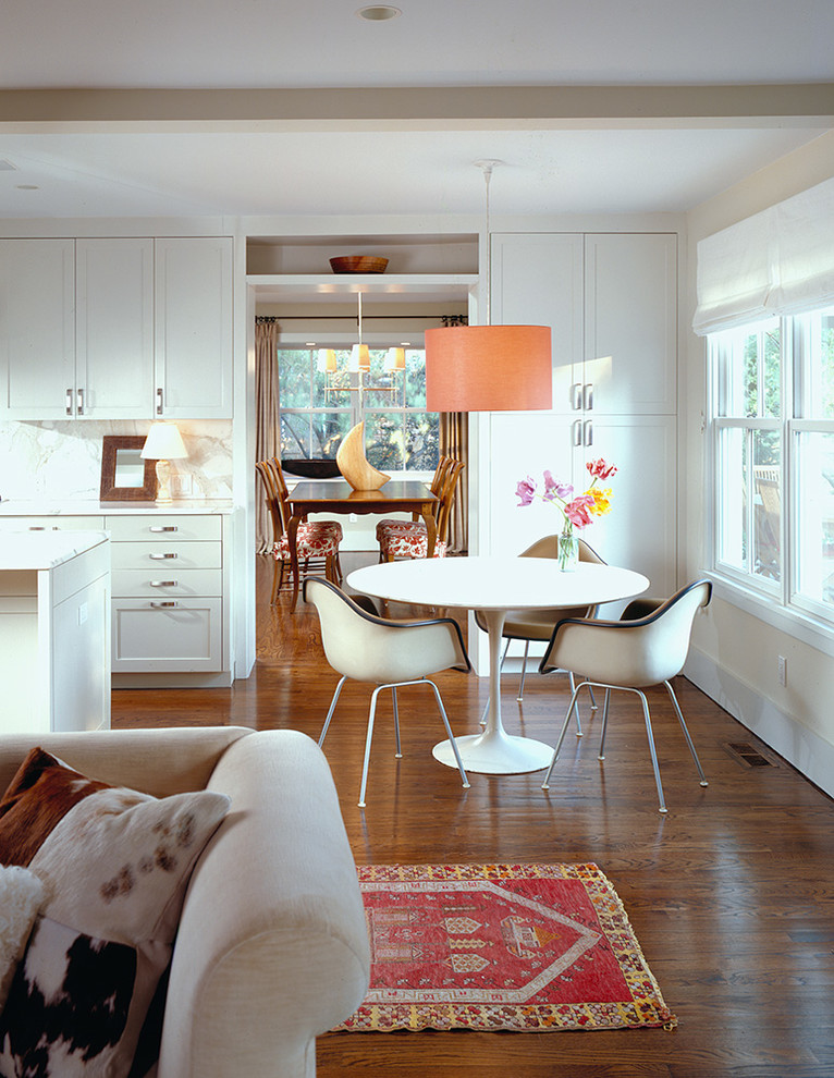 Photo of an open plan dining in New York with white walls and dark hardwood floors.
