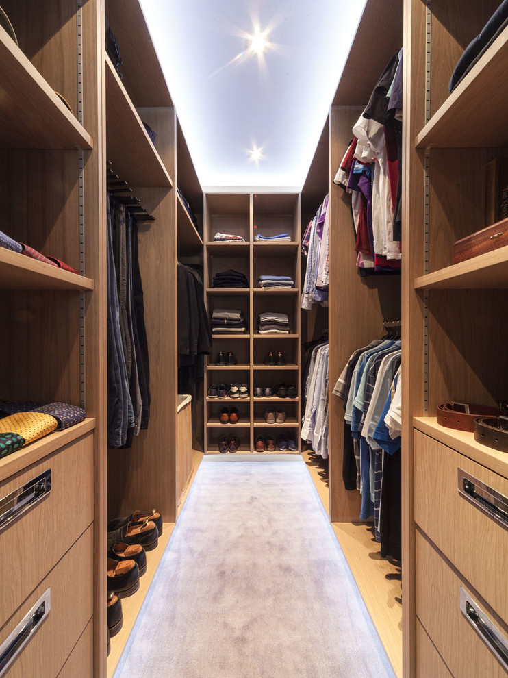 Inspiration for a contemporary men's walk-in wardrobe in London with open cabinets, medium wood cabinets, carpet and grey floor.