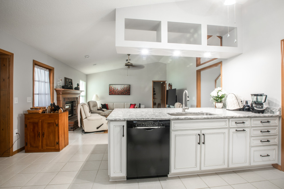 Inredning av ett klassiskt mellanstort grå linjärt grått kök och matrum, med en undermonterad diskho, luckor med infälld panel, vita skåp, bänkskiva i kvarts, grått stänkskydd, stänkskydd i glaskakel och en köksö
