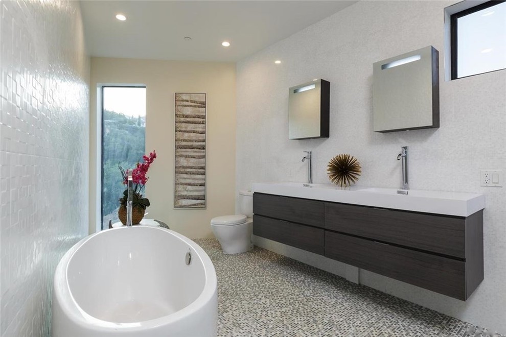Mid-sized modern master bathroom in Los Angeles with flat-panel cabinets, medium wood cabinets, a freestanding tub, an alcove shower, multi-coloured tile, mosaic tile, an integrated sink, beige walls and mosaic tile floors.