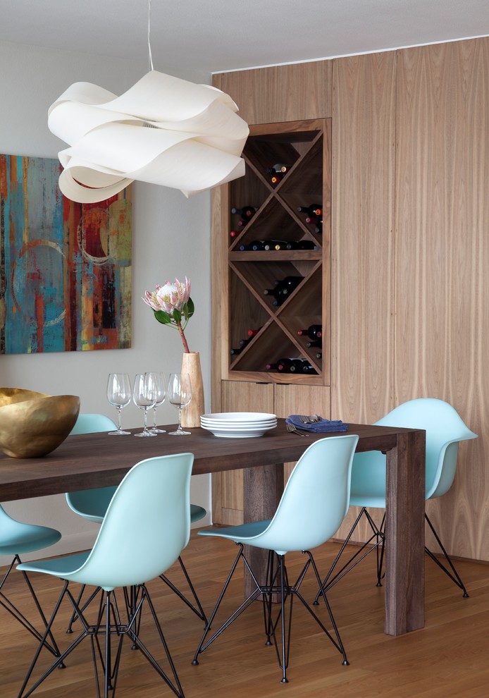 Photo of a midcentury dining room in Austin with white walls and medium hardwood floors.