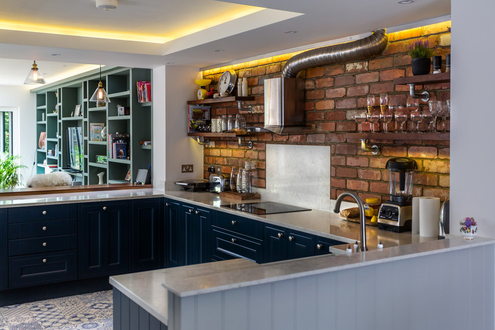 Inspiration for a mid-sized eclectic single-wall open plan kitchen in Berkshire with a farmhouse sink, shaker cabinets, blue cabinets, quartzite benchtops, red splashback, brick splashback, black appliances, ceramic floors, a peninsula and blue floor.