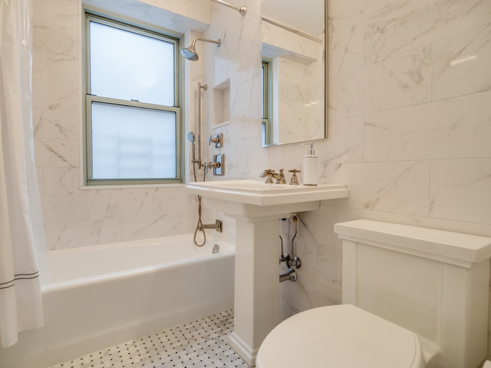 This is an example of a small transitional master bathroom in New York with an alcove tub, a shower/bathtub combo, a two-piece toilet, white tile, marble floors, a pedestal sink, marble benchtops, marble, white walls, grey floor and a shower curtain.