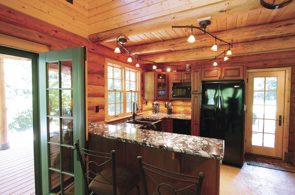 Inspiration for a small rustic u-shaped beige floor and concrete floor kitchen remodel with a farmhouse sink, raised-panel cabinets, medium tone wood cabinets, brown backsplash, wood backsplash, black appliances, a peninsula and granite countertops