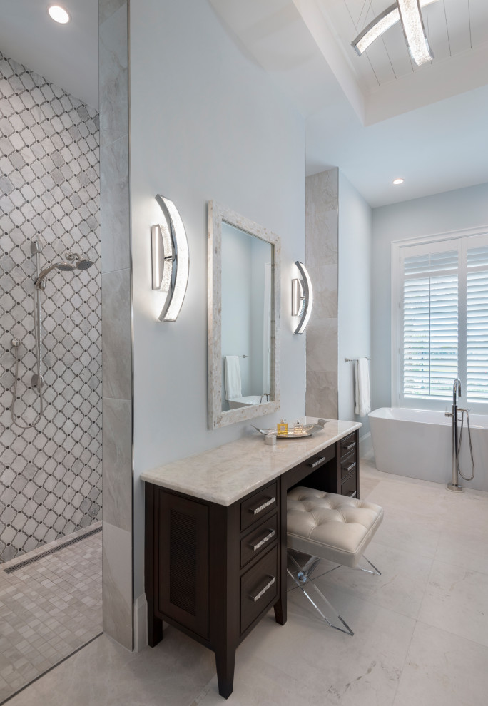 Inspiration for a large beach style master bathroom in Other with beaded inset cabinets, brown cabinets, a freestanding tub, a curbless shower, gray tile, marble, blue walls, marble floors, quartzite benchtops, grey floor, an open shower, white benchtops, a built-in vanity and timber.