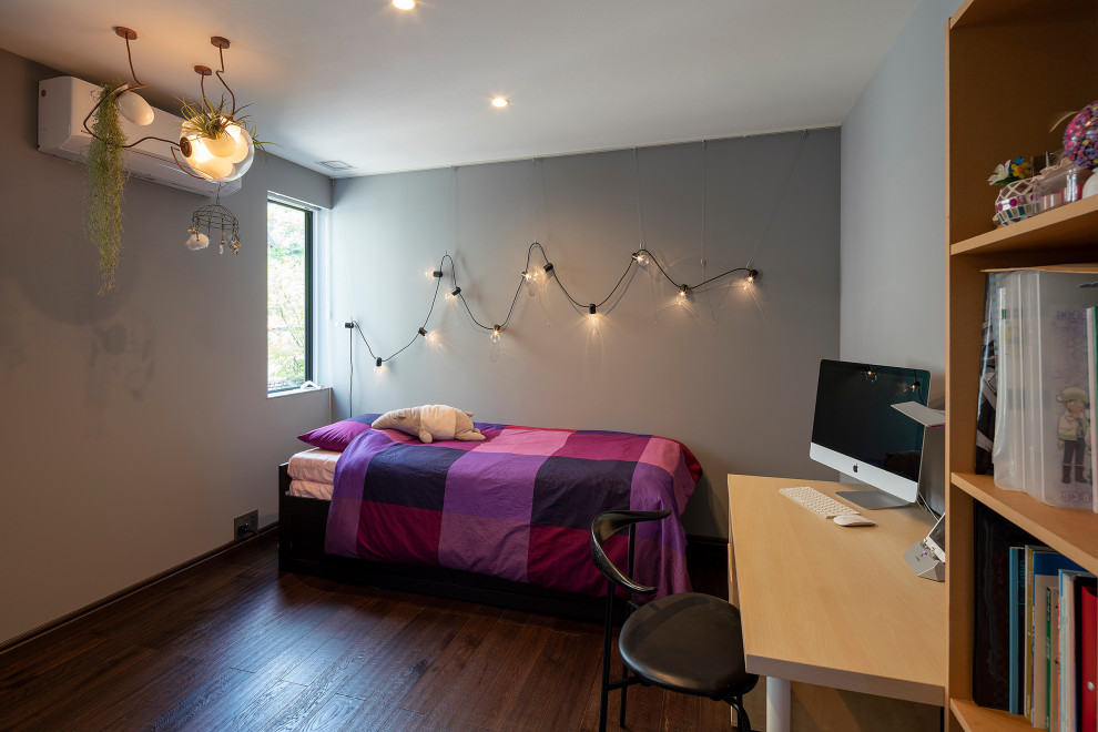 Inspiration pour une chambre d'enfant minimaliste de taille moyenne avec un mur gris, parquet peint et un sol marron.