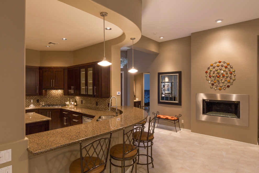 Mid-sized elegant u-shaped travertine floor and beige floor kitchen photo in Phoenix with a double-bowl sink, shaker cabinets, brown cabinets, granite countertops, brown backsplash, mosaic tile backsplash, stainless steel appliances and an island