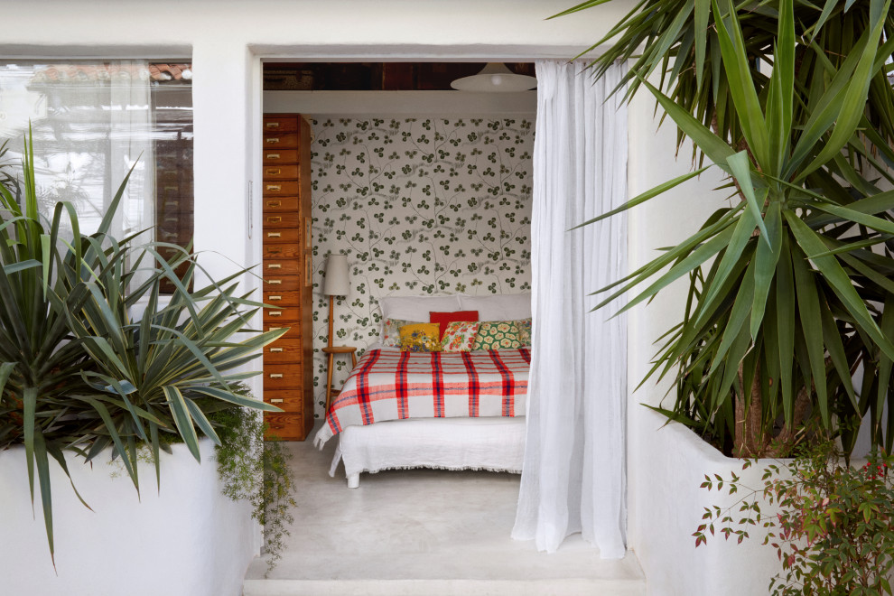 Cette image montre une petite chambre méditerranéenne avec sol en béton ciré et un sol blanc.