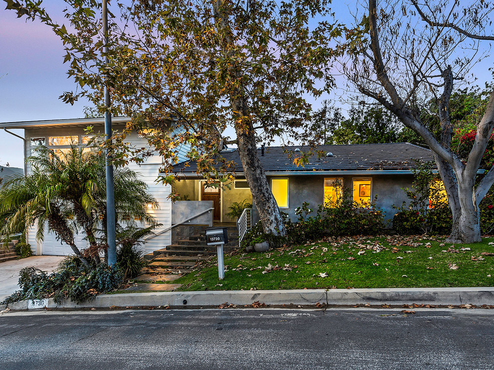 Mid-sized midcentury two-storey grey exterior in Los Angeles with mixed siding and a hip roof.