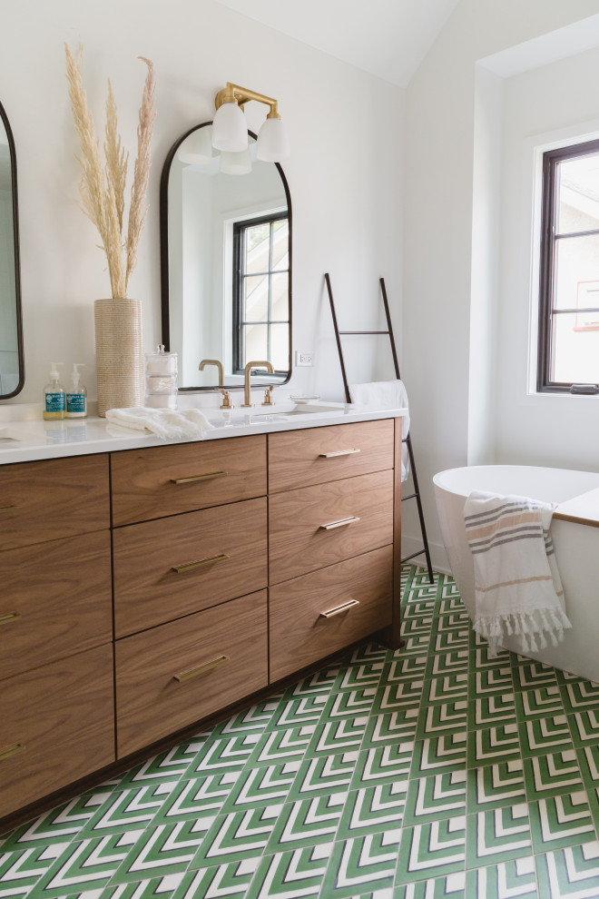 This is an example of a scandinavian master bathroom in Chicago with flat-panel cabinets, medium wood cabinets, a freestanding tub, white walls, multi-coloured floor, white benchtops, a double vanity, a built-in vanity and vaulted.