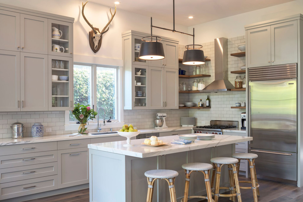 Design ideas for a transitional l-shaped kitchen in San Francisco with an undermount sink, shaker cabinets, grey cabinets, white splashback, subway tile splashback, stainless steel appliances, dark hardwood floors and with island.